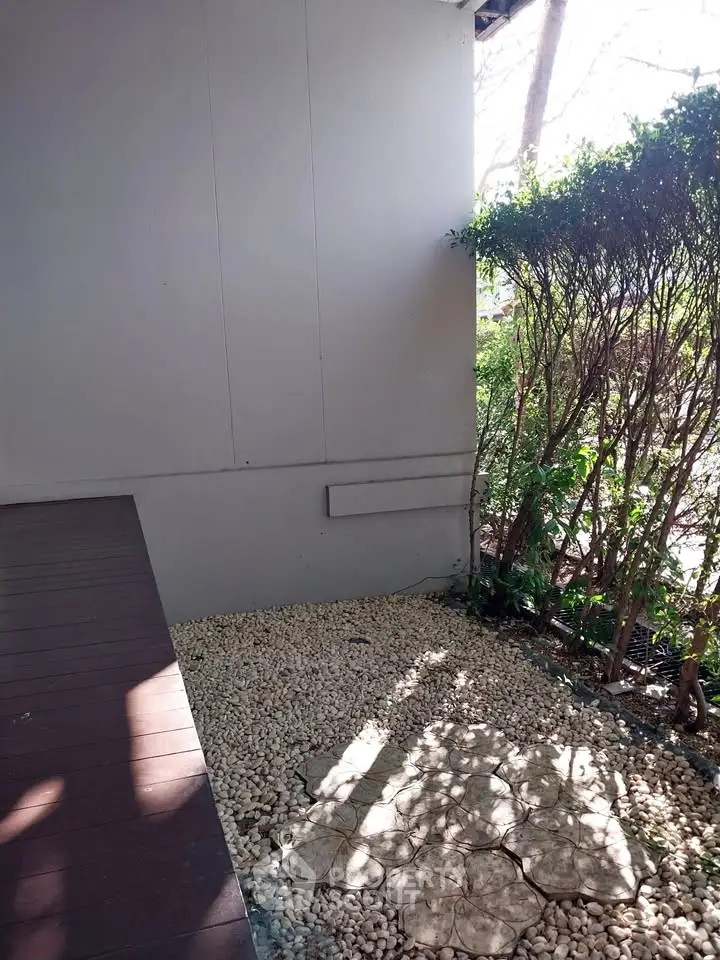 Charming garden corner with pebble pathway and lush greenery