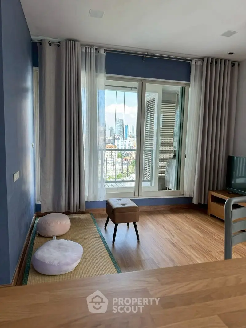 Charming living room with city view and cozy seating area in modern apartment.