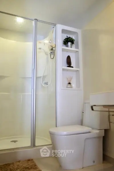 Modern bathroom with glass shower and sleek fixtures in a contemporary home.