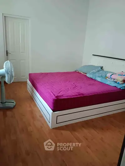 Cozy bedroom with wooden flooring and modern bed frame