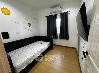 Cozy bedroom with modern decor, featuring a single bed, wall art, and a mounted TV, perfect for relaxation.