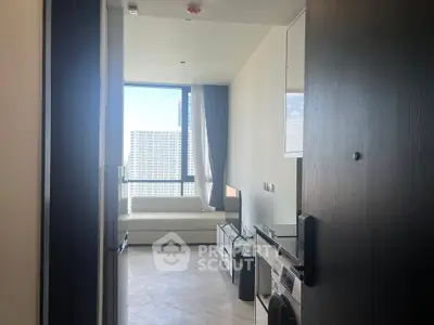 Modern apartment entrance with sleek interior and large window view.