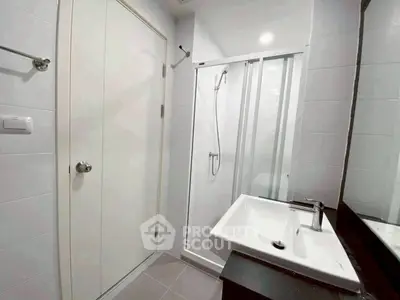 Modern bathroom with sleek shower and stylish sink in contemporary apartment.