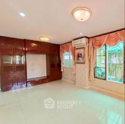 Spacious living room with elegant curtains and built-in wooden cabinets