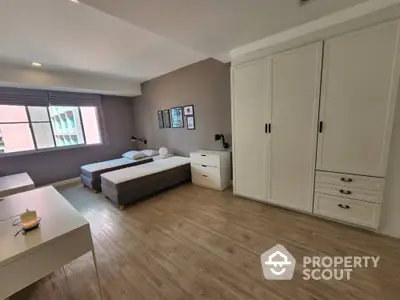 Spacious modern bedroom with twin beds and ample storage in a stylish apartment