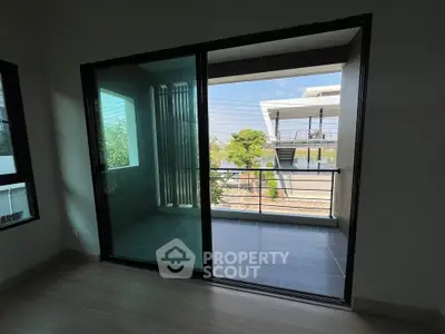 Modern apartment with sliding glass doors leading to a spacious balcony with a view.
