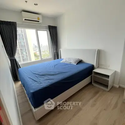 Modern bedroom with large window and city view, featuring a comfortable bed and stylish decor.