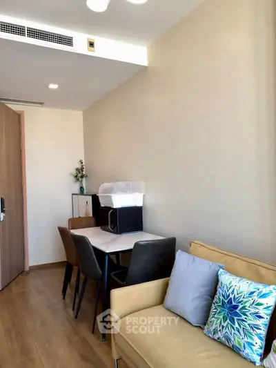Modern living room with cozy seating and dining area, featuring stylish decor and natural light.