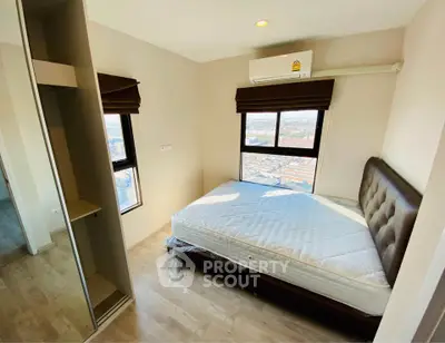 Cozy bedroom with city view, featuring a comfortable bed and modern decor.