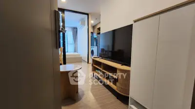 Modern apartment interior with sleek TV unit and cozy bedroom view