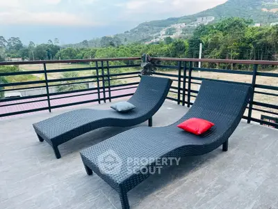 Spacious balcony with stunning mountain views and stylish lounge chairs.