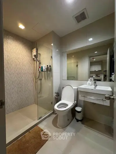 Modern bathroom with glass shower and sleek fixtures in a contemporary home.