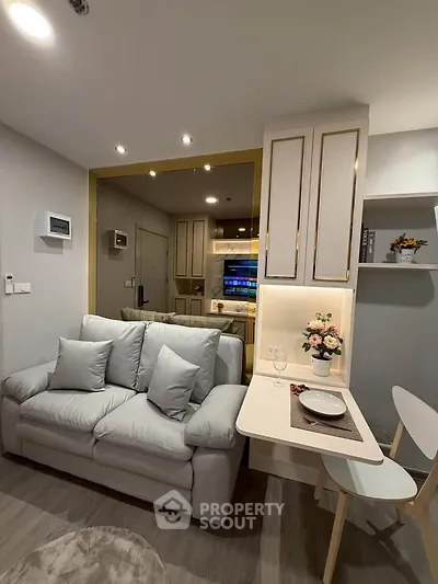 Modern living room with cozy sofa and stylish dining area in open layout apartment.