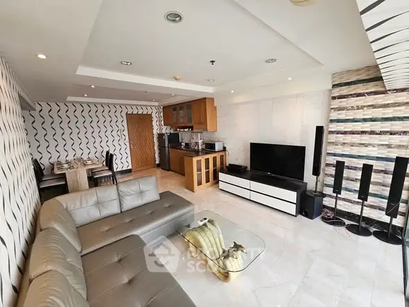 Modern living room with open kitchen, stylish decor, and cozy seating area in a contemporary apartment.