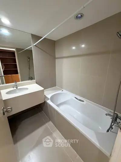 Modern bathroom with sleek design featuring a bathtub and elegant fixtures.