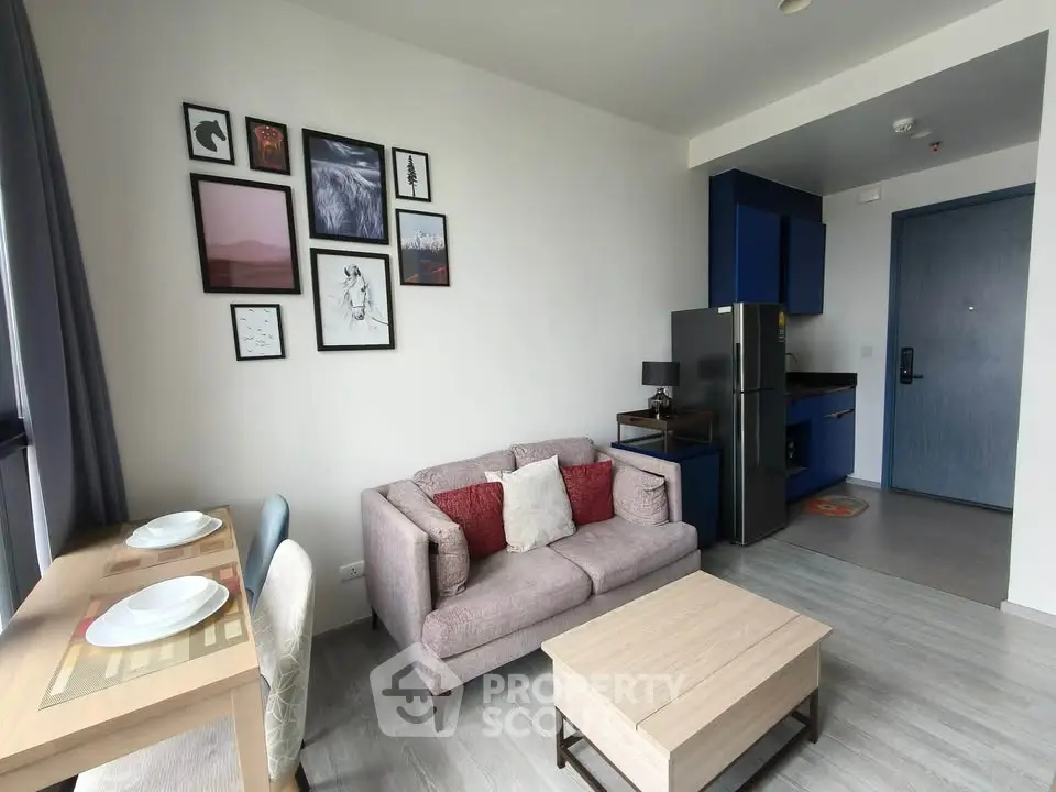 Modern living room with stylish decor and compact kitchen in a cozy apartment.