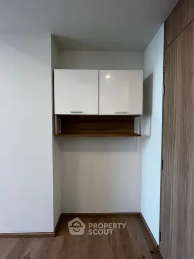 Modern minimalist storage cabinet in a sleek interior space with wooden flooring.