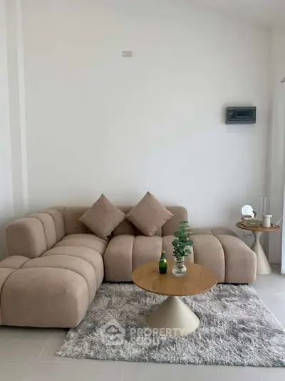 Modern living room with stylish beige sofa and chic coffee table on a plush rug, perfect for cozy gatherings.