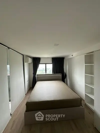 Modern minimalist bedroom with large window and built-in storage