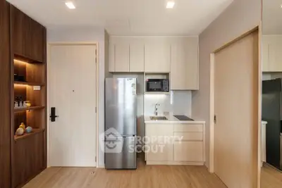 Modern kitchen with sleek appliances and wooden cabinetry in a stylish apartment.