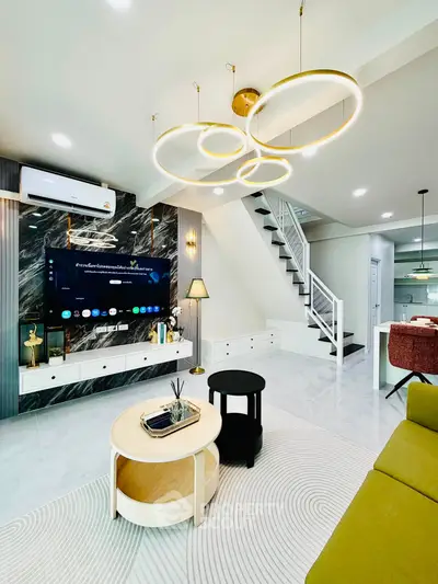 Modern living room with stylish lighting and elegant staircase in a contemporary home.