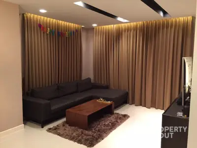 Modern living room with cozy sofa and elegant curtains, perfect for relaxation and entertainment.