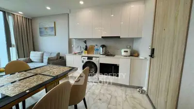 Modern open-layout kitchen and living area with sleek appliances and stylish dining setup.
