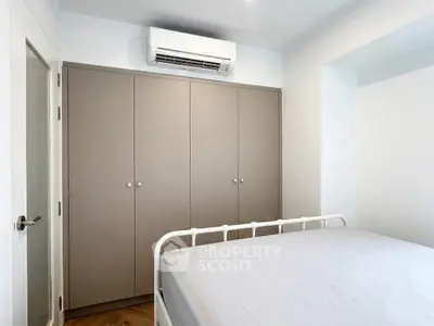 Modern bedroom with built-in wardrobe and air conditioning unit