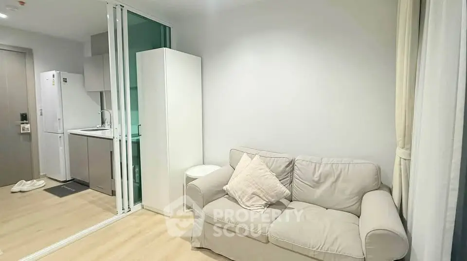 Modern compact living room with cozy sofa and sleek kitchen area