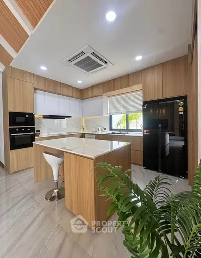 Modern kitchen with sleek wooden cabinetry and island, featuring built-in appliances and a stylish open layout.