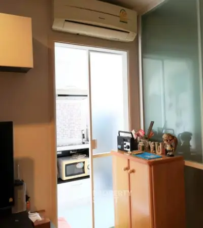 Cozy interior with air conditioning and sliding door leading to a modern kitchen.