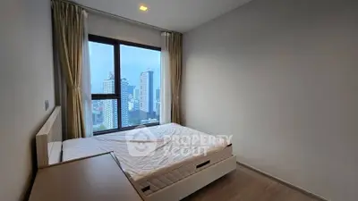 Modern bedroom with city view and large window in high-rise apartment