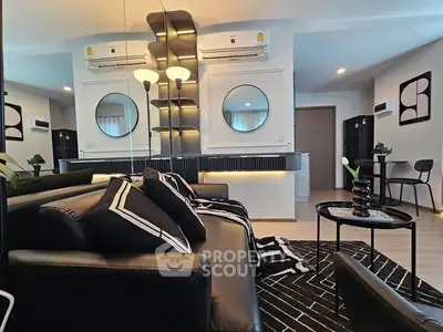 Modern living room with stylish black leather sofa and chic decor