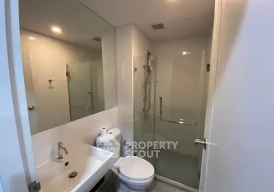 Modern bathroom with glass shower and sleek fixtures in a contemporary apartment.