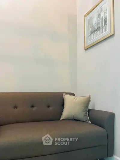 Cozy living room with elegant sofa and framed artwork, perfect for relaxation and style.