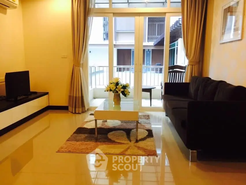 Spacious living room with modern decor and balcony access in a stylish apartment.