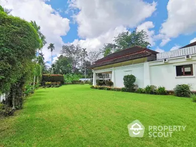 Spacious garden view with lush greenery and charming house exterior