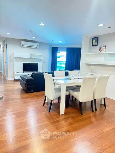 Spacious modern living room with dining area and sleek furniture in a stylish apartment.
