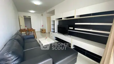 Modern living room with sleek black leather sofa and stylish entertainment unit