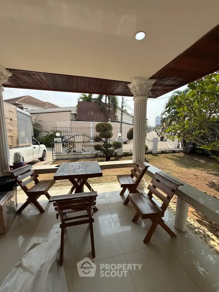 Charming outdoor patio with wooden furniture and garden view, perfect for relaxation and entertaining.