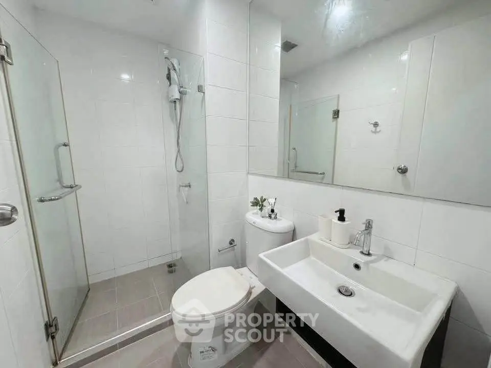 Modern white bathroom with glass shower and sleek fixtures