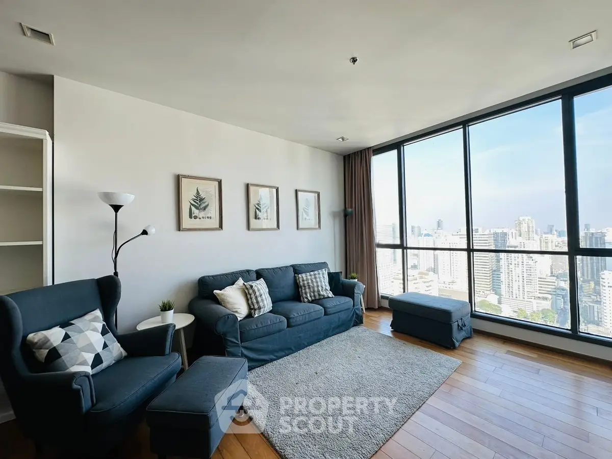Spacious living room with panoramic city view and modern furnishings.