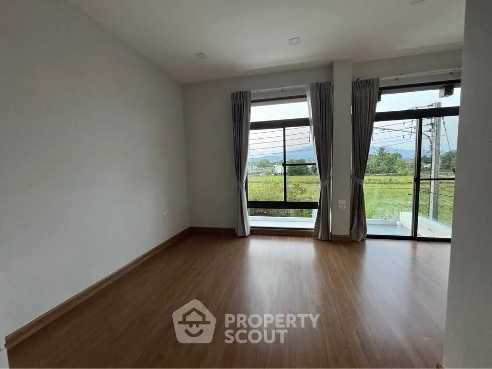 Spacious empty room with large windows offering scenic views, perfect for customization.
