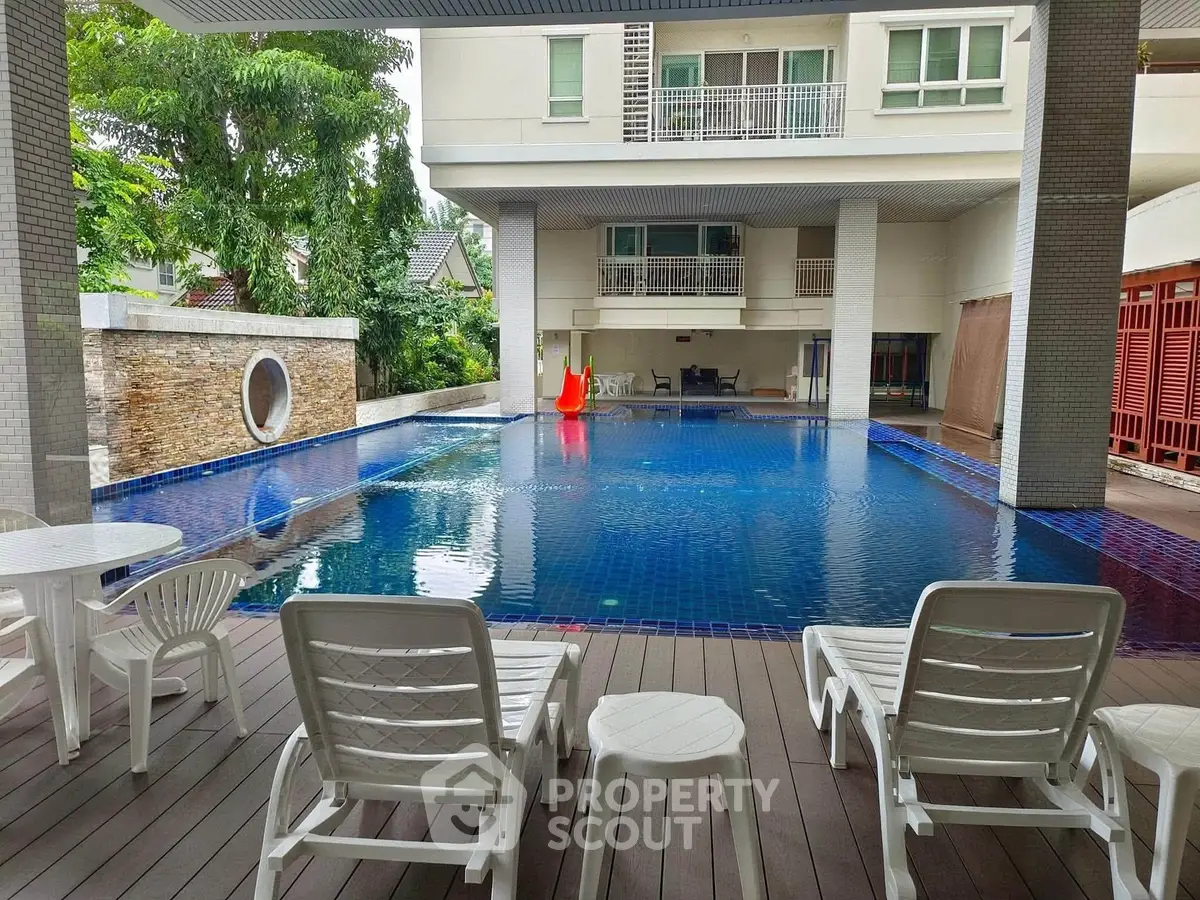 Luxurious residential pool area with stylish deck chairs and serene ambiance.
