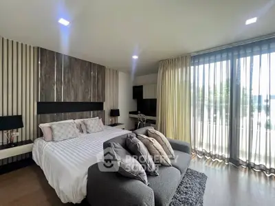 Luxurious bedroom with modern decor and large windows offering natural light