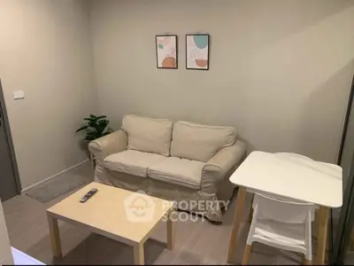 Cozy living room with beige sofa, modern decor, and minimalist furniture.