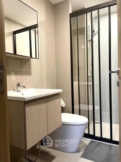 Modern bathroom with sleek shower enclosure and stylish vanity in contemporary apartment.