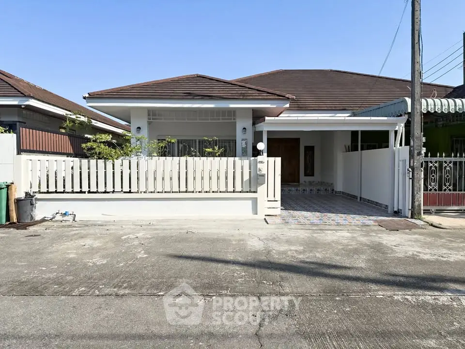 Charming single-story house with a fenced front yard and tiled entrance, perfect for cozy living.