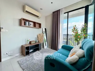 Cozy living room with teal sofa and balcony view