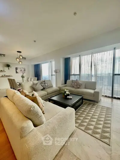 Spacious modern living room with elegant decor and large windows offering stunning views.